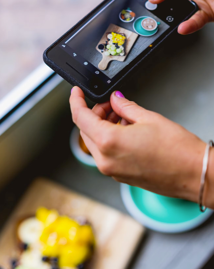 Undistinguishable person taking a photo of food with their smartphone